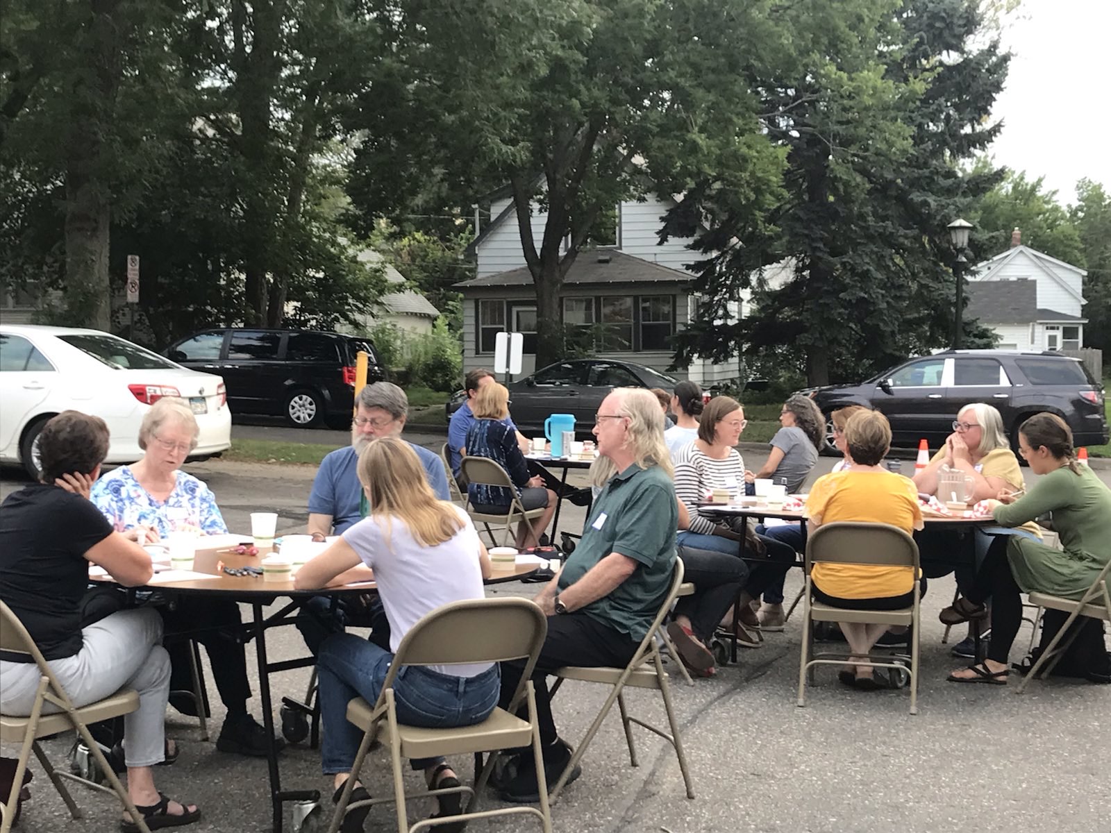 People sit at outdoor tables in a Respectful Conversation in Saint Paul